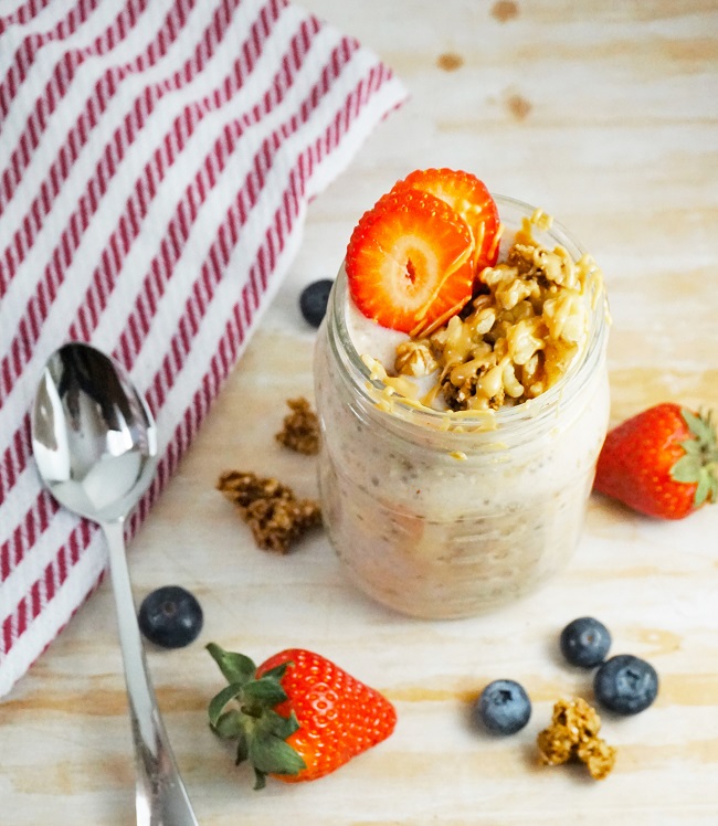 Photo of Banana Cream Pie Overnight Oats in a Mason Jar with a spoon and scattered fruit